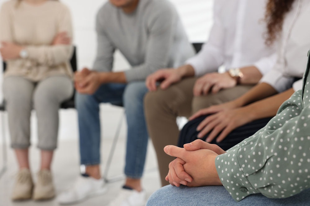 alcohol-rehab-center Lower shot of people seated in a circle during alcohol addiction treatment