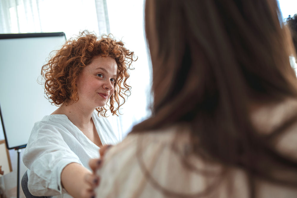 Woman reassuring another woman in bipolar disorder support group.