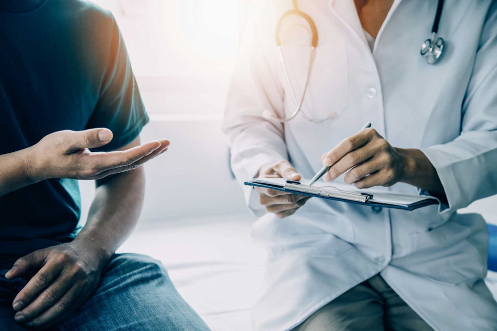 Man holding conversation with doctor about insurance for rehab.