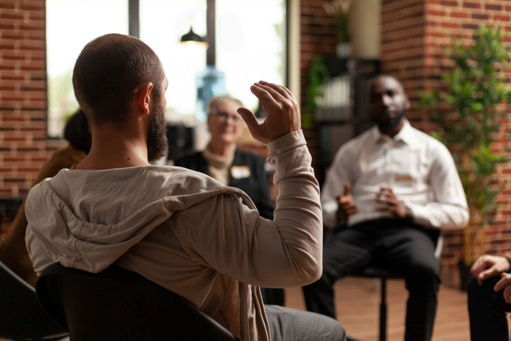 Man gesturing while seated in addiction treatment in Lancaster, PA